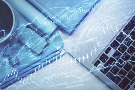 Double exposure of forex graph drawing over desktop background with computer. Concept of financial...