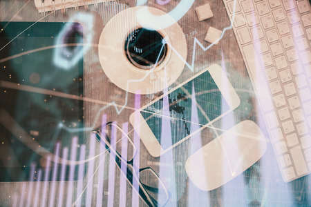 Multi exposure of forex graph hologram over desktop with phone. Top view. Mobile trade platform...