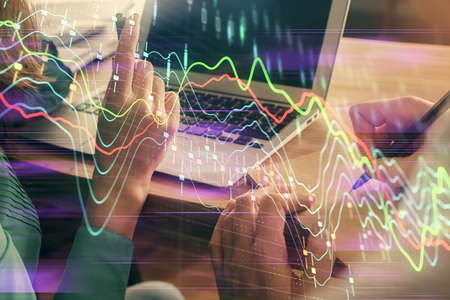 Double exposure of man and woman working together and forex chart hologram. Business concept. Computer background.の写真素材