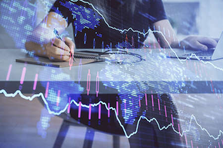Double exposure of businesswoman hands typing on computer and forex chart hologram drawing....