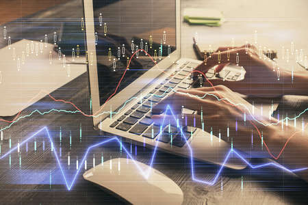 Double exposure of woman hands typing on computer and forex chart hologram drawing. Stock market...