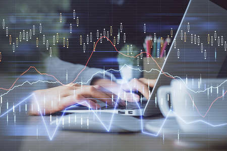 Double exposure of woman hands typing on computer and forex chart hologram drawing. Stock market...