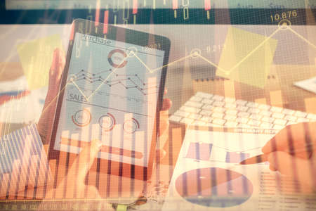 Multi exposure of mans hands holding and using a phone and financial chart drawing. Market analysis...