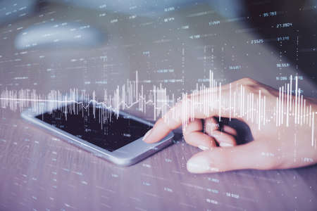 Double exposure of forex chart sketch hologram and woman holding and using a mobile device....
