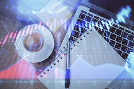 Double exposure of forex chart drawing over table background with computer. Concept of financial...