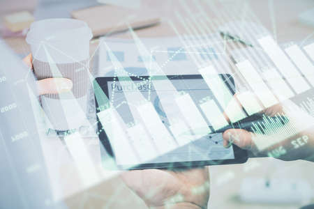 Double exposure of mans hands holding and using a phone and financial chart drawing. Market analysis...