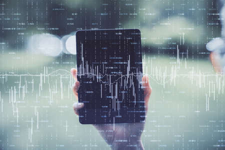 Double exposure of forex chart sketch hologram and woman holding and using a mobile device....