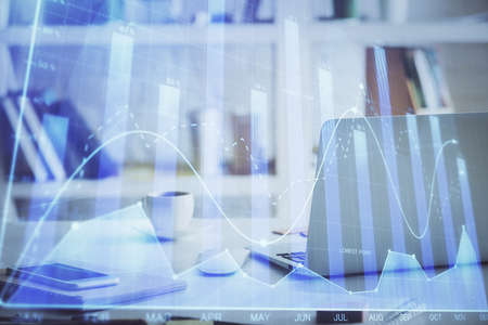 Stock market graph on background with desk and personal computer. Multi exposure. Concept of financial analysis.の写真素材