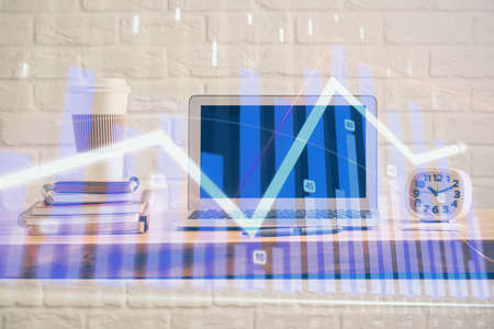 Forex market chart hologram and personal computer background. Double exposure. Concept of investment.の写真素材