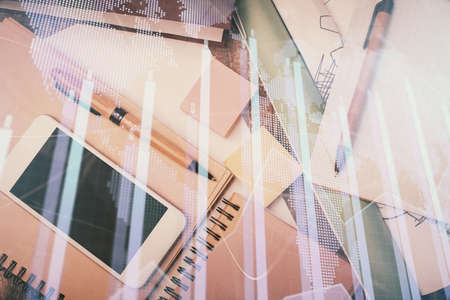 Multi exposure of forex graph hologram over desktop with phone. Top view. Mobile trade platform concept.の写真素材