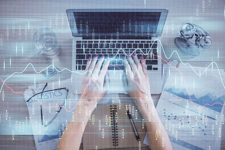 Double exposure of woman hands working on computer and forex graph hologram drawing. Top View....