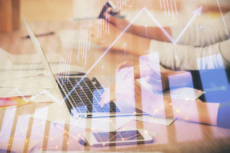 Multi exposure of woman hands typing on computer and financial chart hologram drawing. Stock market...