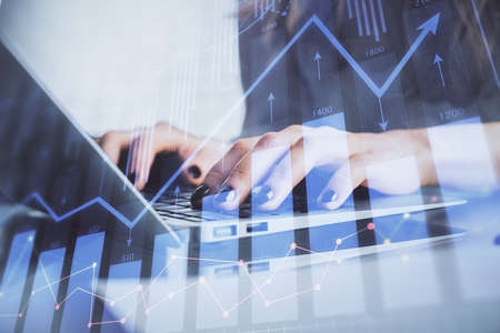 Double exposure of woman hands typing on computer and forex chart hologram drawing. Stock market...