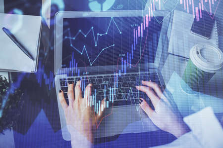 Double exposure of woman hands typing on computer and forex chart hologram drawing. Stock market...