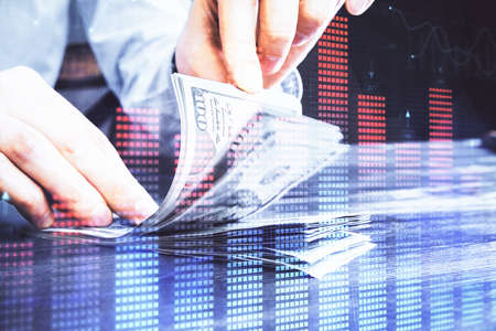 Multi exposure of forex graph drawing hologram and USA dollars bills and man hands. Technical...