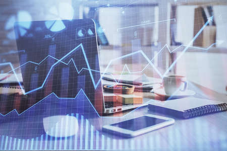 Financial chart drawing and table with computer on background. Multi exposure. Concept of...