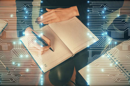 Tech theme hologram over womans hands taking notes background. Concept of hightech. Double exposure