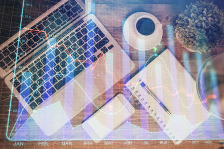 Financial market graph and top view computer on the desktop background. Double exposure. Investment concept.の写真素材