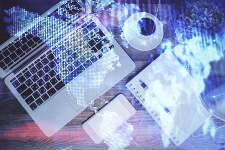 Financial market graph and top view computer on the desktop background. Double exposure. Investment...