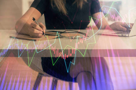 Double exposure of businesswoman hands typing on computer and forex chart hologram drawing. Financial analysis concept.の写真素材