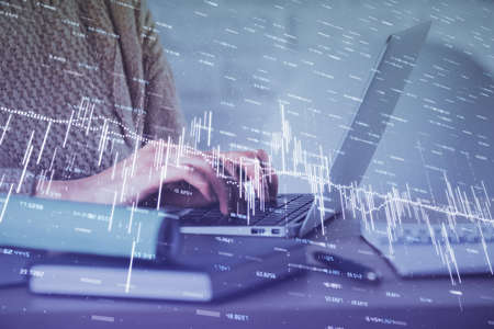 Double exposure of woman hands typing on computer and forex chart hologram drawing. Stock market...