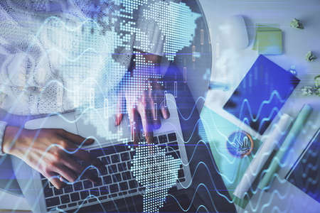 Multi exposure of woman hands working on computer and forex chart hologram drawing. Top View....