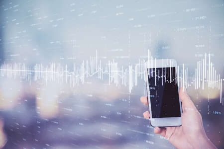 Double exposure of forex chart sketch hologram and woman holding and using a mobile device. Stock market concept.の写真素材