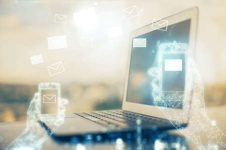 Desktop computer background in office and flying envelops hologram drawing. Double exposure. Electronic mail concept.の写真素材