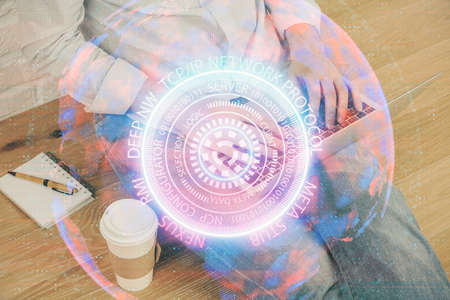 Technology theme hologram with man working on computer on background. High tech concept. Multi...