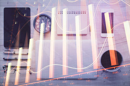Double exposure of forex graph hologram over desktop with phone. Top view. Mobile trade platform concept.の写真素材