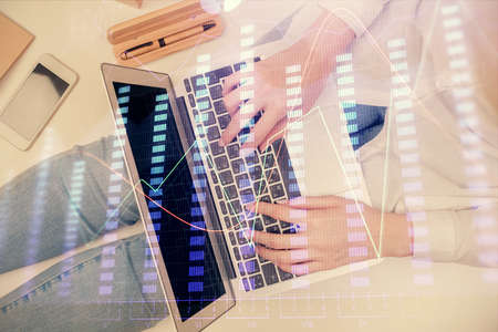 Double exposure of woman hands working on computer and forex graph hologram drawing. Top View. Financial analysis concept.の写真素材