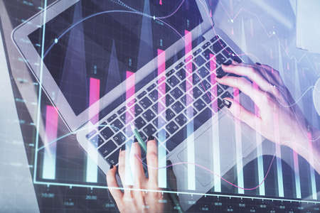 Double exposure of woman hands working on computer and forex chart hologram drawing. Top View....