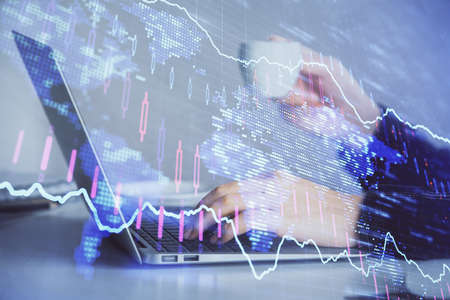 Double exposure of businesswoman hands typing on computer and forex graph hologram drawing....