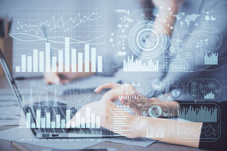 Multi exposure of woman hands typing on computer and financial chart hologram drawing. Stock market...