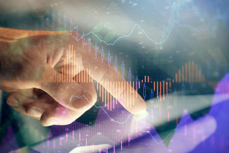 Multi exposure of mans hands holding and using a phone and financial chart drawing. Market analysis...