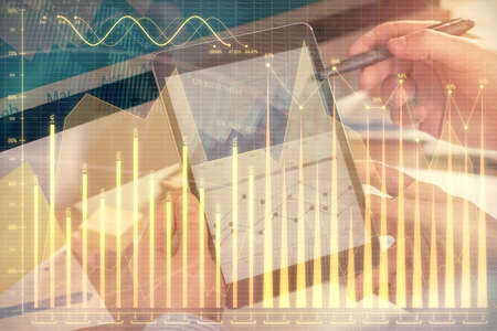 Double exposure of mans hands holding and using a phone and financial chart drawing. Market analysis...