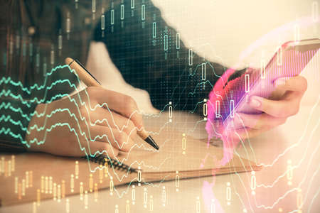 Double exposure of forex graph sketch hologram and woman holding and using a mobile device. Stock...