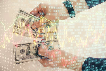 Multi exposure of financial graph drawing hologram and USA dollars bills and man hands. Analysis...