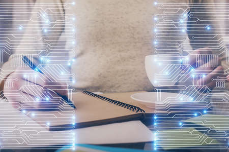 Tech theme hologram over womans hands taking notes background. Concept of hightech. Double exposure