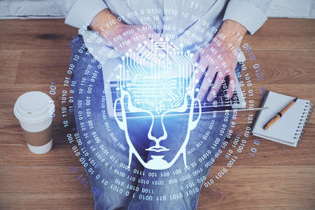 Businessman with computer background with brain theme hologram. Concept of brainstorm. Multi...