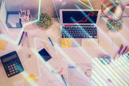 Double exposure of forex chart drawing over table background with computer. Concept of financial...