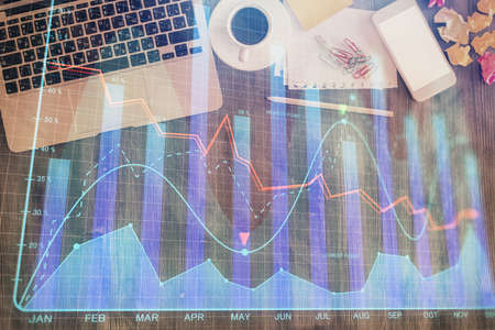 Financial market graph and top view computer on the desktop background. Double exposure. Investment concept.の写真素材