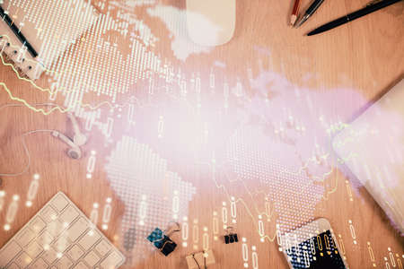 Multi exposure of forex graph hologram over desktop with phone. Top view. Mobile trade platform...