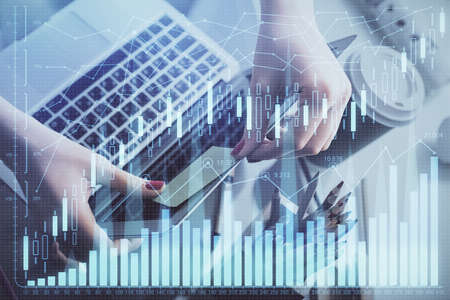 Double exposure of businesswoman hands typing on computer and financial graph hologram drawing....