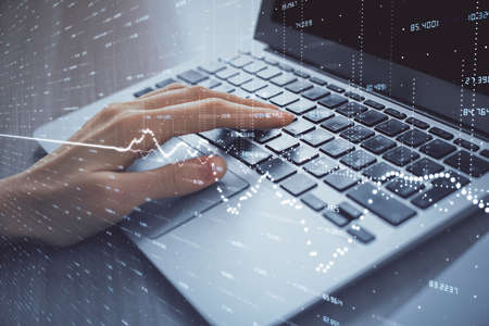 Double exposure of woman hands typing on computer and forex chart hologram drawing. Stock market...