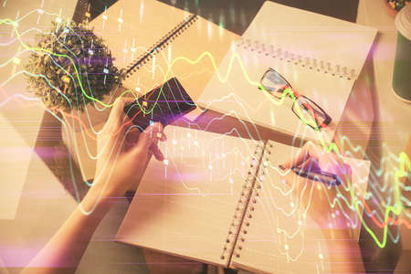 Multi exposure of woman on-line shopping holding a credit card and financial graph drawing. Stock...