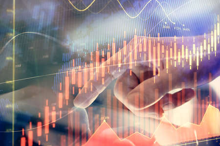 Multi exposure of mans hands holding and using a phone and financial chart drawing. Market analysis...