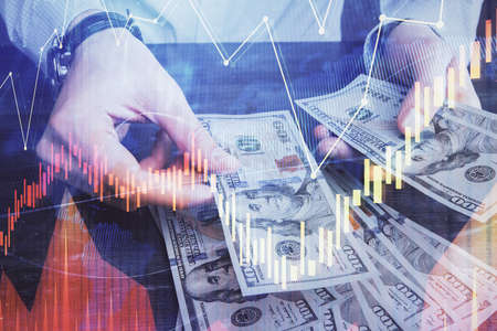 Multi exposure of financial graph drawing hologram and USA dollars bills and man hands. Analysis...