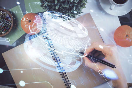 Double exposure of writing hand on background with data solution technology hologram. Ai concept.の写真素材