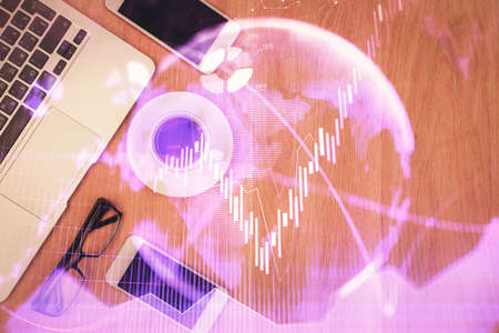 Double exposure of forex chart hologram over desktop with phone. Top view. Mobile trade platform...